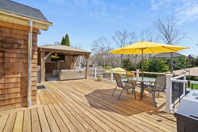 wooden deck with outdoor dining area, a gazebo, and an outdoor living space
