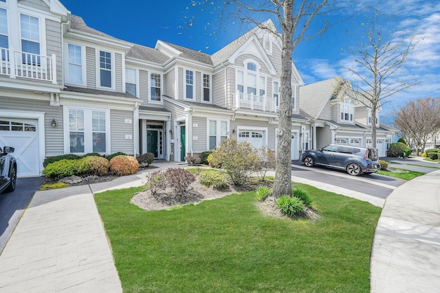 10 Symphony Dr, Lake Grove, NY 11755 - view of front of home featuring a garage, a residential view, driveway, a balcony, and a front yard