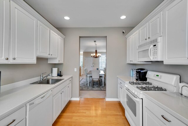 10 Symphony Dr, Lake Grove, NY 11755 - kitchen with a chandelier, white cabinets, white appliances, and a sink