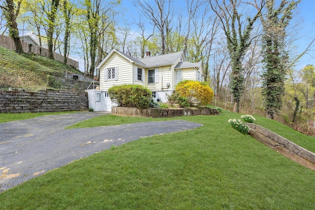view of home's exterior featuring a chimney and a yard