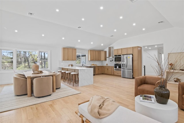 living area with recessed lighting, visible vents, lofted ceiling, and light wood-style floors