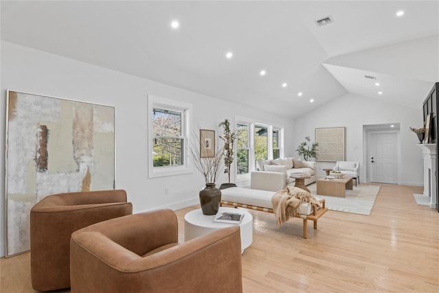 living room featuring visible vents, a fireplace, high vaulted ceiling, light wood-style floors, and recessed lighting