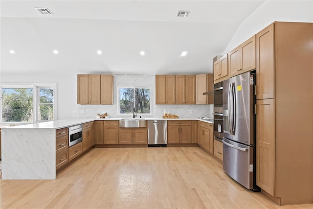kitchen featuring stainless steel appliances, visible vents, plenty of natural light, and a peninsula