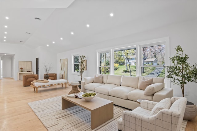 living area with recessed lighting, high vaulted ceiling, visible vents, and light wood-style flooring