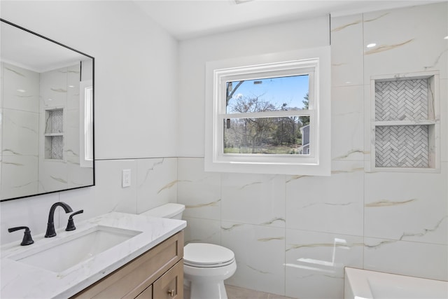 bathroom featuring toilet, tile walls, and vanity