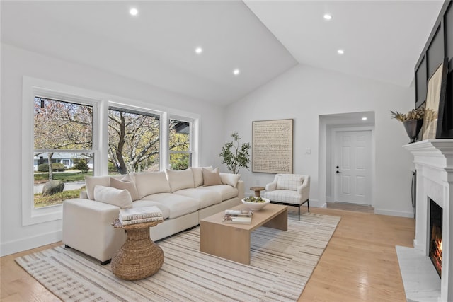 7 Breezy Hill Dr, Northport, NY 11768 - living area with a fireplace with flush hearth, light wood-style floors, recessed lighting, and lofted ceiling