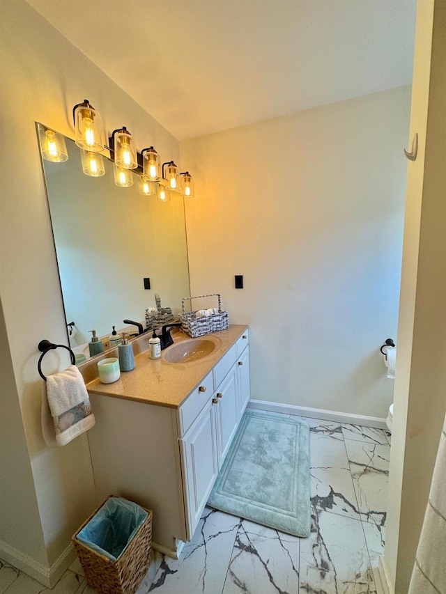 bathroom with baseboards, marble finish floor, and vanity
