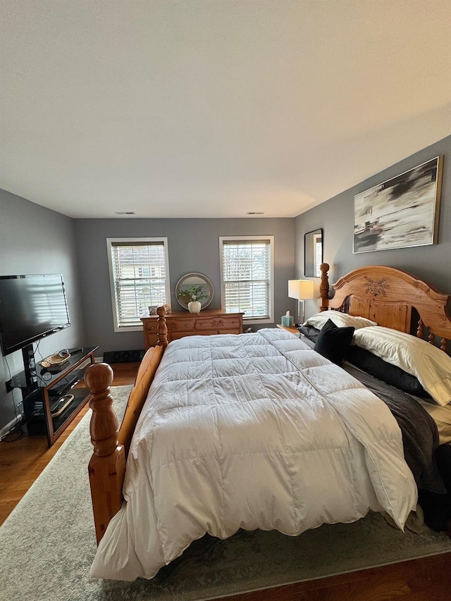 bedroom with wood finished floors and multiple windows