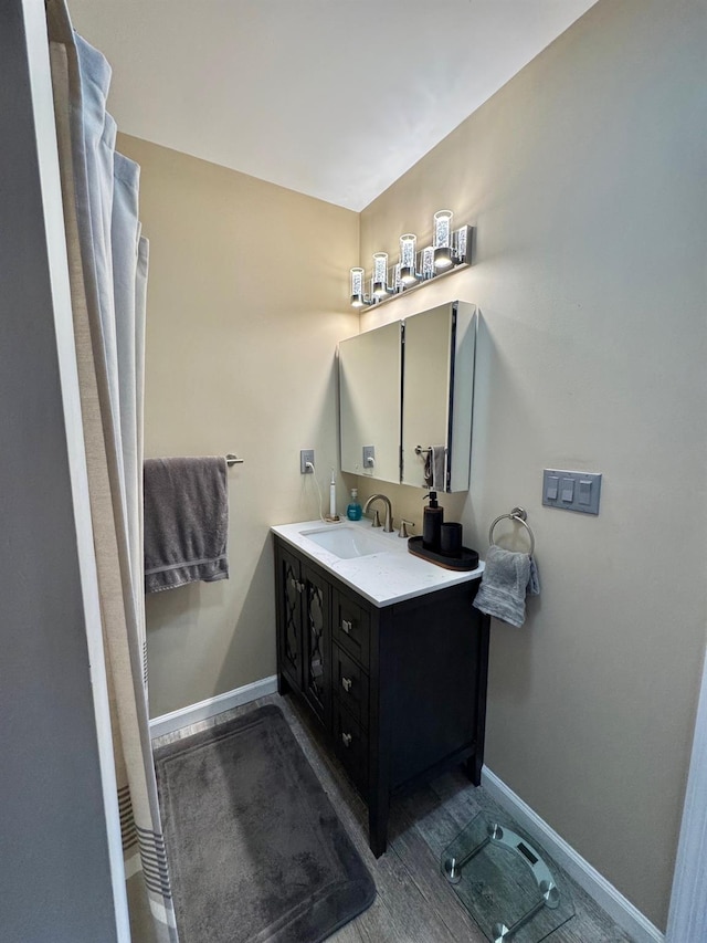full bathroom featuring baseboards and vanity