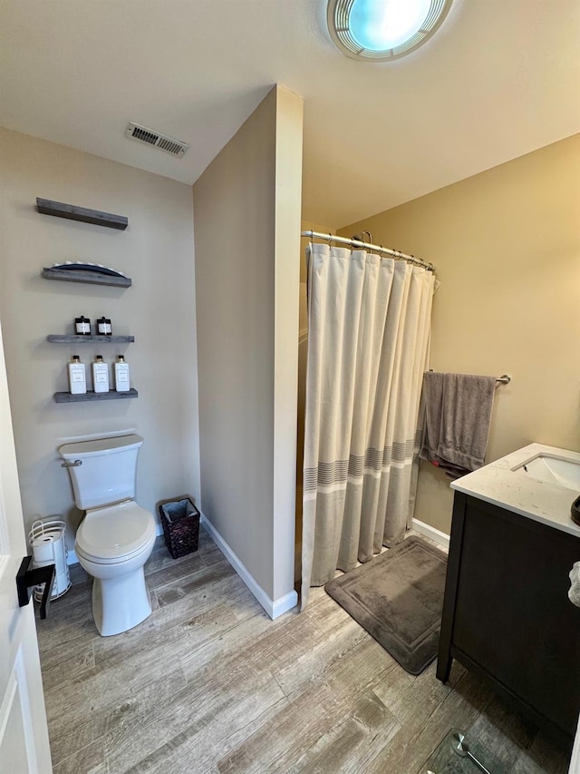 full bathroom with wood finished floors, visible vents, toilet, and a stall shower