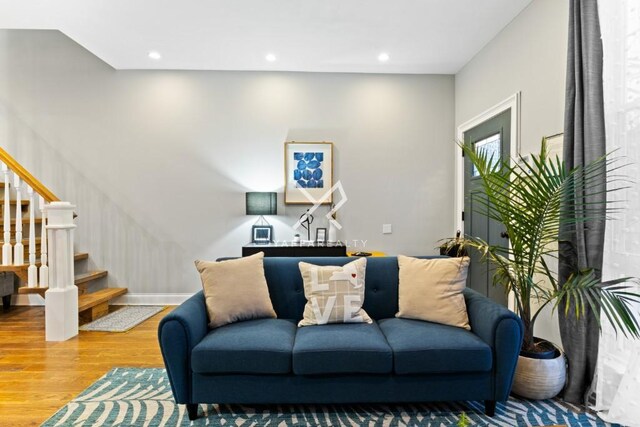 living area featuring wood finished floors, recessed lighting, and stairs