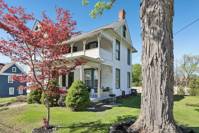 10 Wheeler Ave, Warwick, NY 10990 - view of front of house with a porch, a front lawn, a balcony, and a chimney
