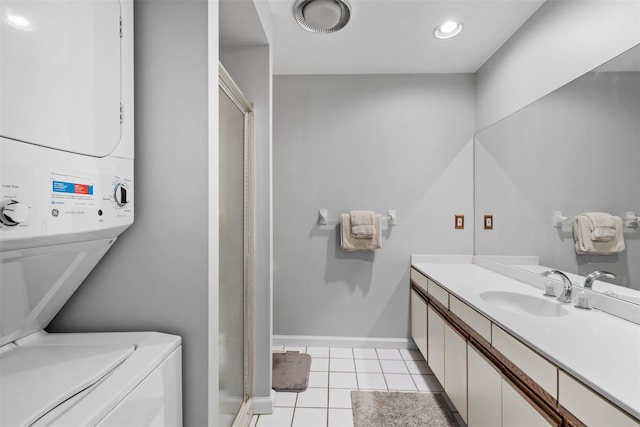 full bathroom featuring tile patterned flooring, vanity, baseboards, stacked washing maching and dryer, and a stall shower