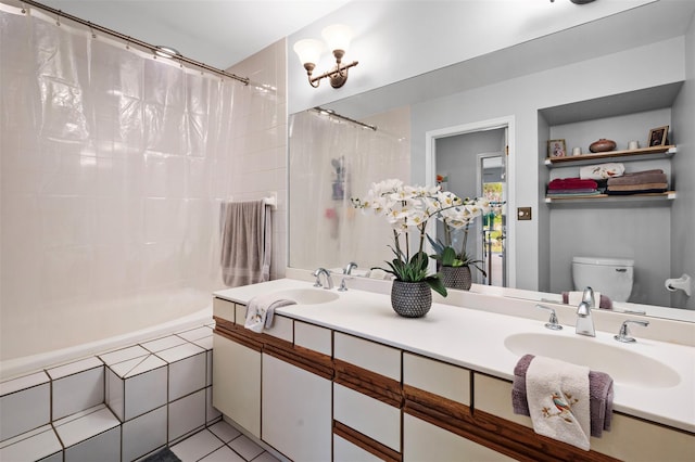 bathroom featuring a sink, toilet, double vanity, tiled shower / bath combo, and tile patterned flooring
