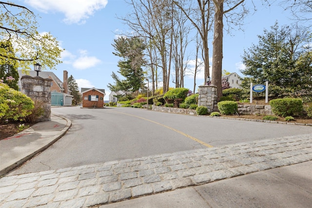view of road featuring curbs, sidewalks, and street lights
