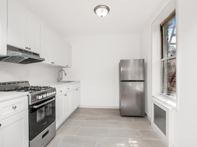 6535 Broadway Unit 5C, Bronx, NY 10471 - kitchen with stainless steel appliances, under cabinet range hood, a sink, light countertops, and white cabinetry