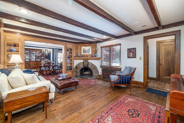 living room with beamed ceiling, wood finished floors, a healthy amount of sunlight, and baseboards