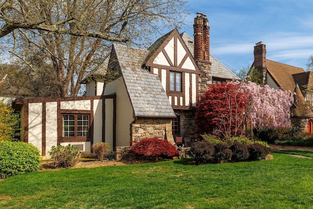exterior space with a high end roof, a lawn, stone siding, and stucco siding