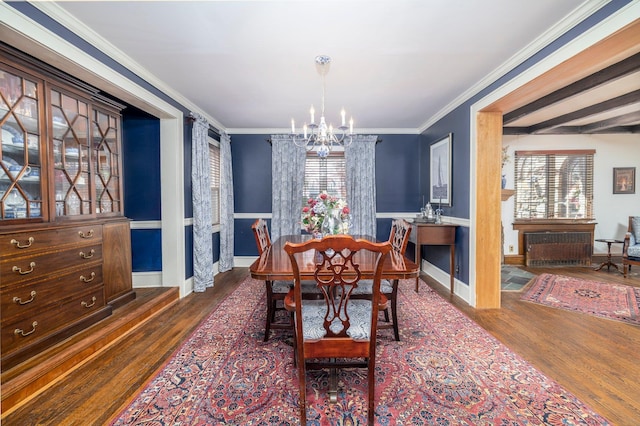 dining space featuring wood finished floors, a chandelier, and ornamental molding