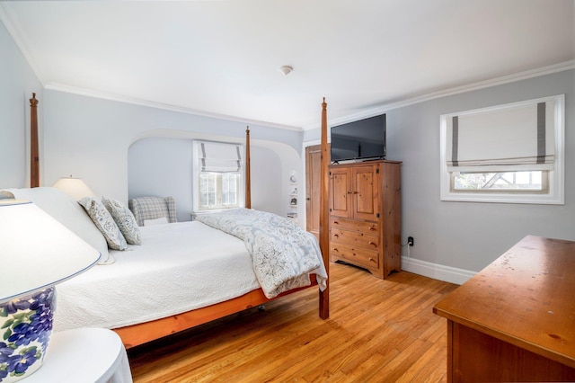 bedroom featuring arched walkways, crown molding, and light wood-style flooring