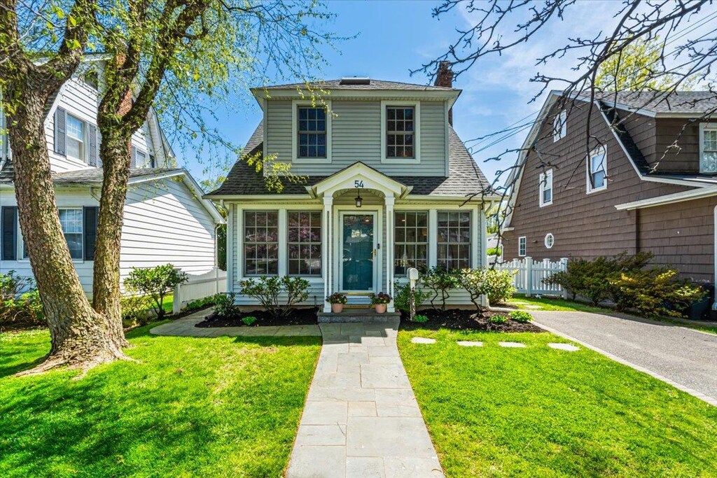 54 Park Ave, Port Washington, NY 11050 - view of front of property with fence, a chimney, a shingled roof, and a front yard