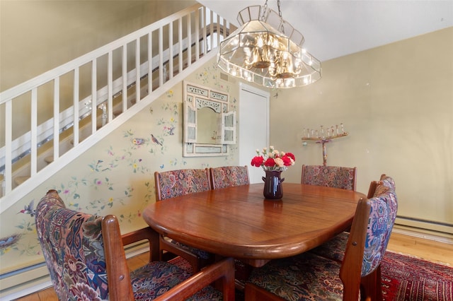dining space featuring wood finished floors, a notable chandelier, stairs, and a baseboard radiator