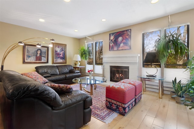 living area with a fireplace, recessed lighting, and light wood finished floors