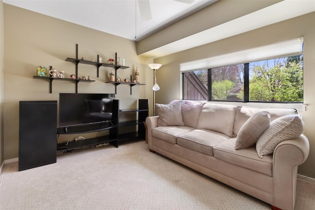 living area featuring baseboards, a ceiling fan, and carpet flooring
