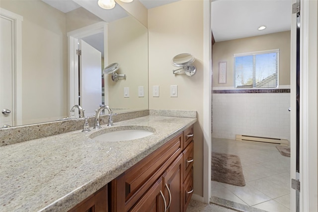 bathroom with a baseboard heating unit, tile patterned flooring, and vanity