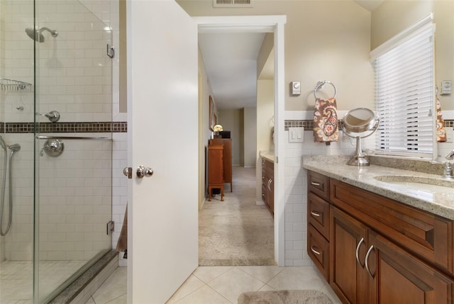 ensuite bathroom featuring a shower stall, visible vents, tile patterned floors, vanity, and ensuite bath