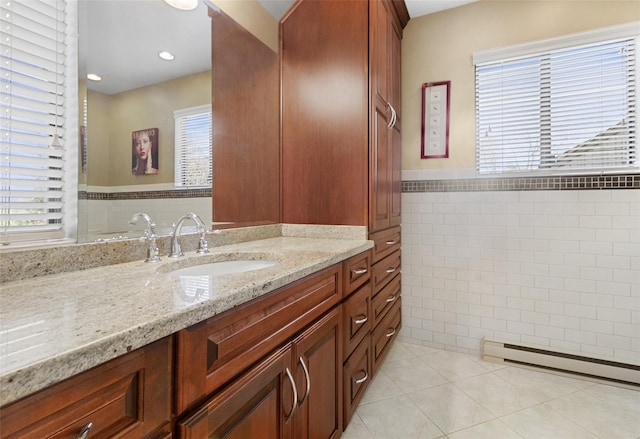 bathroom with tile walls, a wealth of natural light, tile patterned flooring, and vanity