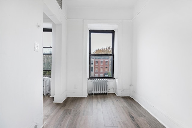 201 Madison St, Brooklyn, NY 11216 - empty room featuring radiator, baseboards, wood finished floors, and visible vents