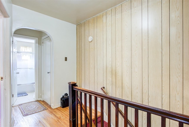 225-54 Murdock Ave, Queens Village, NY 11429 - hall with an upstairs landing, wood walls, light wood-type flooring, and arched walkways