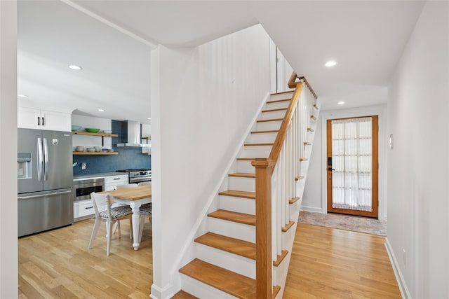 staircase featuring baseboards, recessed lighting, and wood finished floors