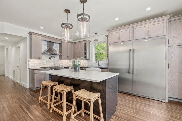 16 Anderson Rd, Pawling, NY 12564 - kitchen featuring stainless steel built in fridge, wall chimney exhaust hood, tasteful backsplash, wood finished floors, and recessed lighting