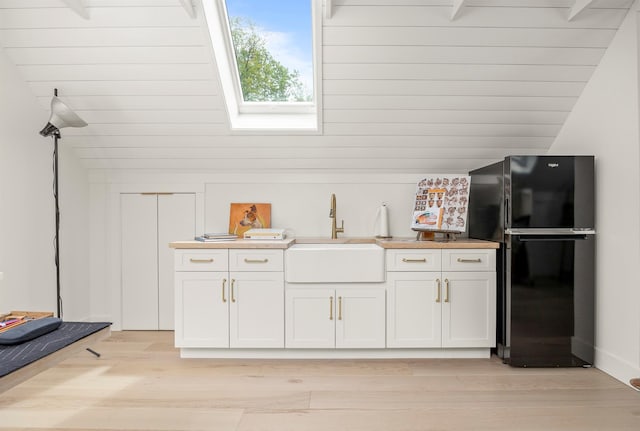 16 Anderson Rd, Pawling, NY 12564 - kitchen with freestanding refrigerator, a skylight, a sink, vaulted ceiling, and light wood-style flooring