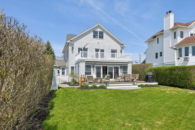 back of property with a patio area, a yard, a balcony, and fence