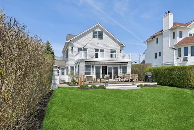 back of property with a lawn, fence, a balcony, and a patio area