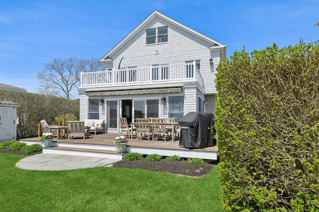 back of property with an outdoor living space, a lawn, a balcony, and outdoor dining space