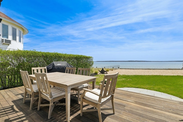 wooden deck with a lawn, cooling unit, a water view, outdoor dining space, and a grill