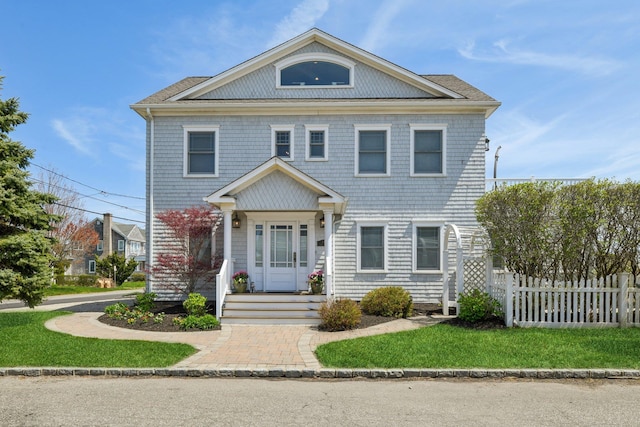 greek revival inspired property featuring fence and a front yard
