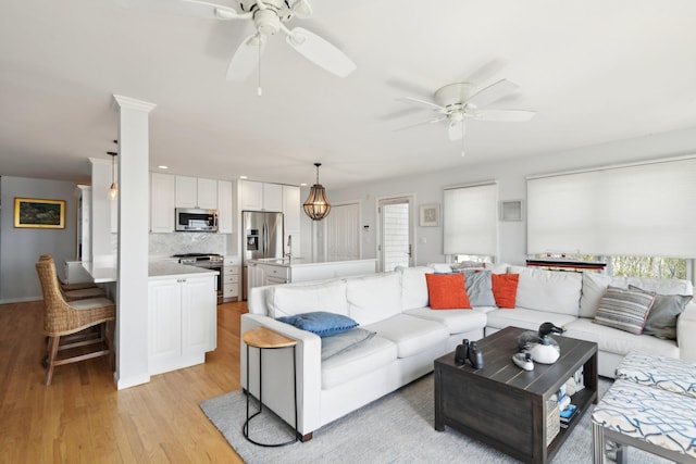 living area featuring ceiling fan and light wood finished floors
