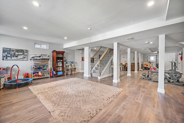 below grade area with stairs, recessed lighting, baseboards, and wood finished floors