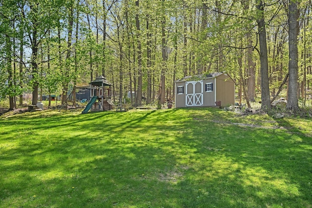 view of yard featuring an outbuilding, a shed, and a playground