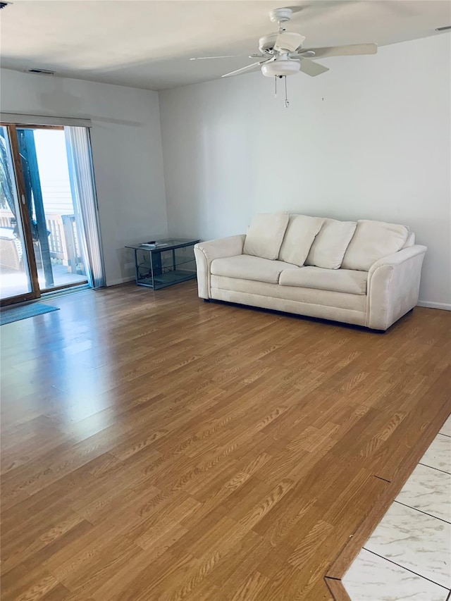 living area with light wood finished floors, ceiling fan, baseboards, and visible vents