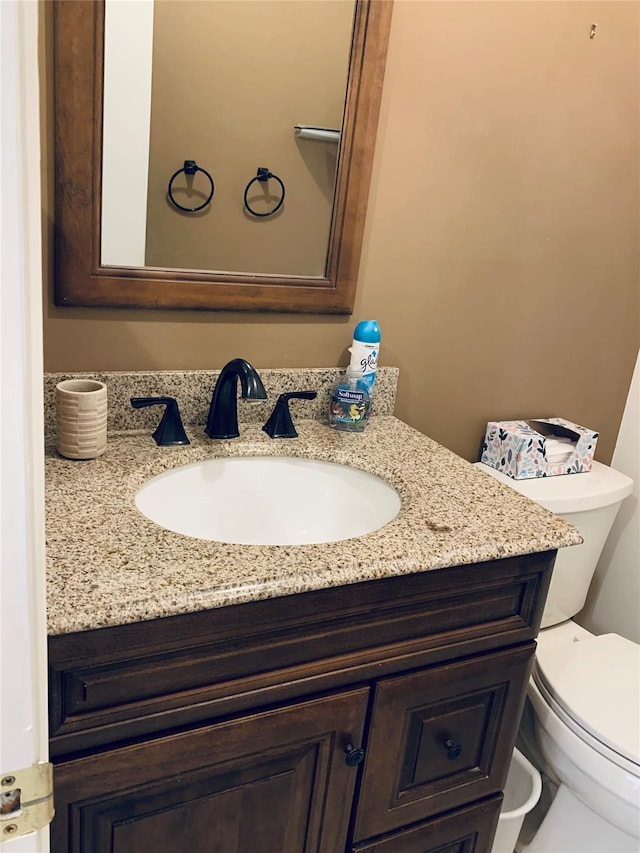 half bath featuring toilet and vanity