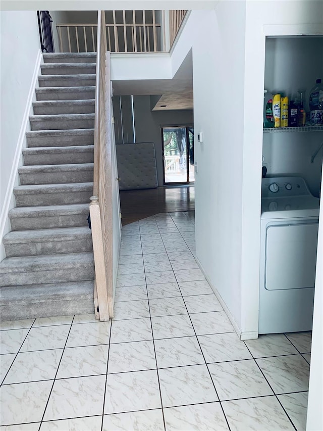 stairway with washer / dryer, marble finish floor, and baseboards