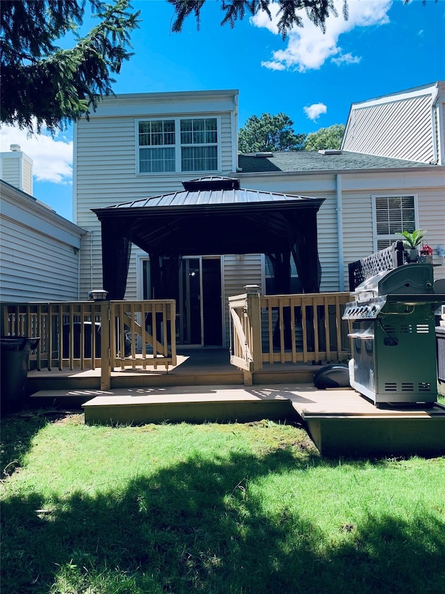 rear view of house featuring a gazebo, a yard, and a wooden deck