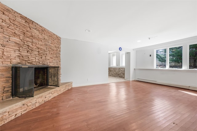 29 Fairway Dr, Rocky Point, NY 11778 - unfurnished living room featuring a baseboard radiator, baseboards, wood finished floors, and a fireplace