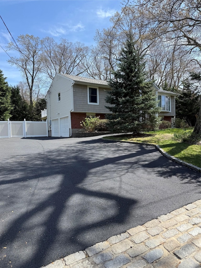29 Fairway Dr, Rocky Point, NY 11778 - view of front facade with a garage, driveway, and fence